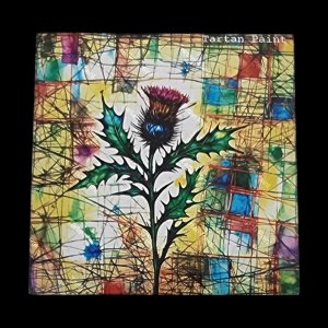 Scottish fridge magnet featuring a vibrant thistle with tartan colours and stained-glass style design