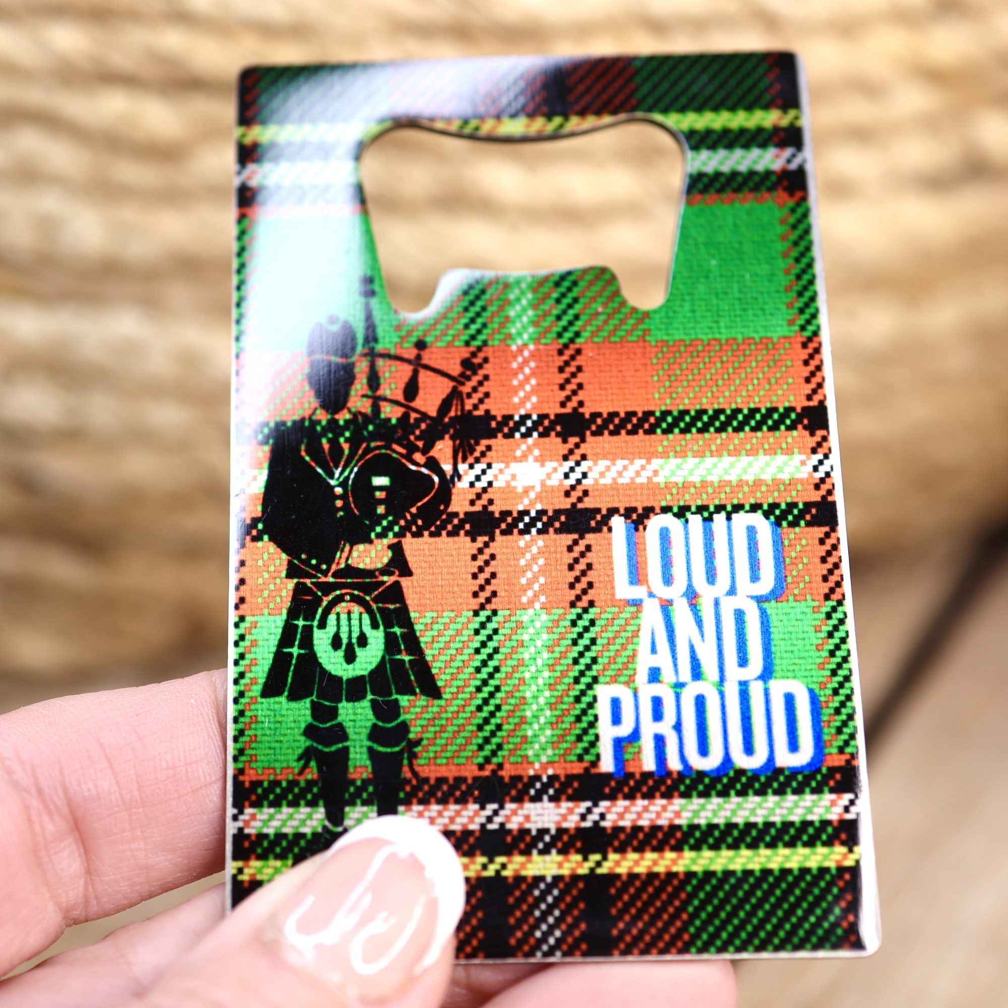 Loud and Proud piper wallet bottle opener held in a hand